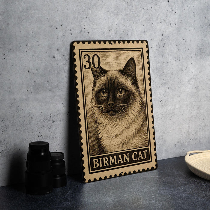 A metal stamp featuring a close-up of a Siamese cat's face, with the text "BIRMAN CAT" printed on it.