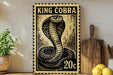 A framed image of a cobra, a type of snake, is displayed on a wall next to a wooden cutting board and some lemons.