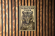 A framed image of a tiger on a wooden wall.