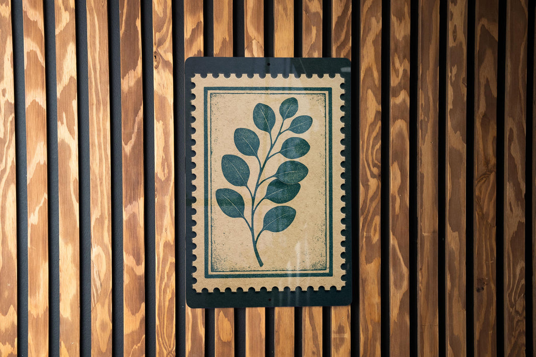a wooden wall with a framed print of a leafy plant on it.