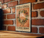 A vintage-style metal sign with the text "MIDSUMMER FLOWER CROWN" is displayed on a brick wall, with a wooden table below it.