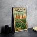 A vintage-style metal sign with the text "ALOE VERA GARDEN" and an illustration of aloe vera plants.
