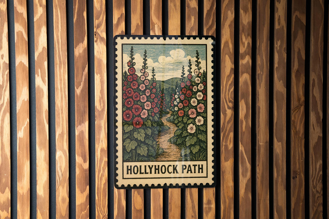 A framed illustration of a floral path, with the text "Hollyhock Path" below it, is displayed on a wooden wall.