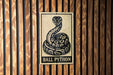 A sign with a snake image and the text "BALL PYTHON" is displayed on a wooden wall.