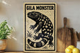 a wooden sign with a black and white illustration of a gila monster, a type of lizard, on a shelf next to a wooden cutting board and some lemons.