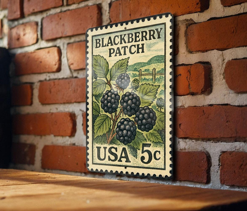 A vintage postage stamp featuring a blackberry patch, mounted on a brick wall.
