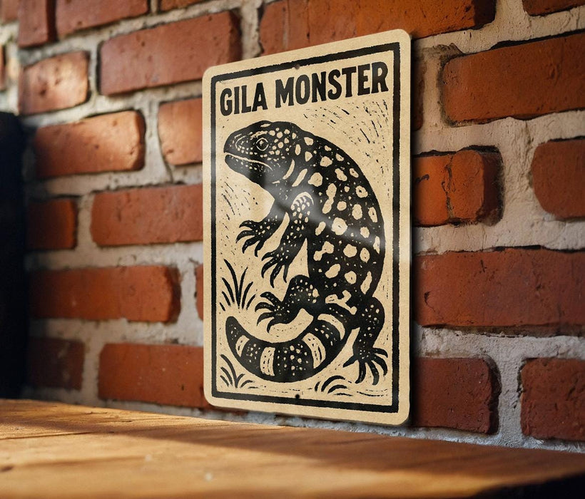 A sign featuring a black and white illustration of a gila monster, a type of lizard, against a brick wall background.