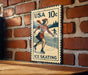 A vintage-style postage stamp featuring an illustration of a woman ice skating, mounted on a brick wall.