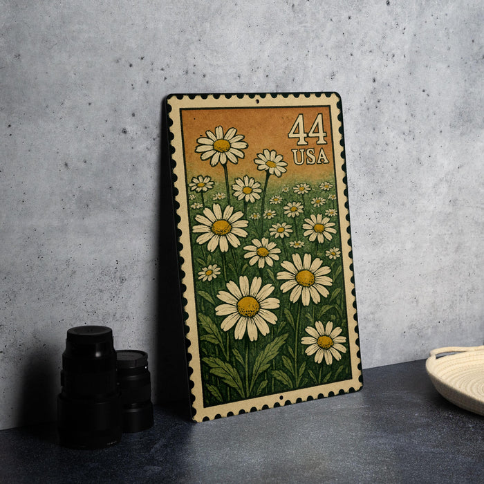 A metal stamp with a floral design and the number 44 printed on it, placed on a table next to some black camera lenses.