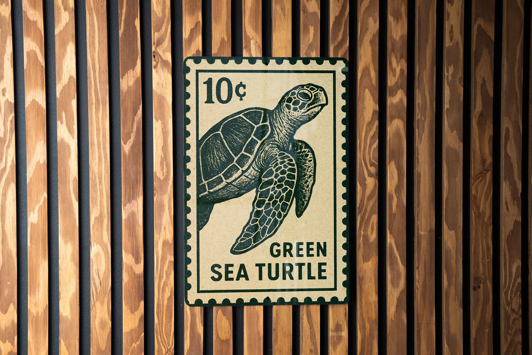 A green sea turtle stamp is displayed on a wooden wall.