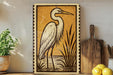 a large framed illustration of a heron standing in a natural setting, with a wooden cutting board and a potted plant nearby.