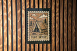 A sign with a tent illustration and the word "TENT SETUP" is mounted on a wooden wall.