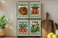 a collection of four seed packets, each depicting a different vegetable: tomatoes, carrots, radishes, and corn. The seed packets are arranged on a shelf, with a wooden cutting board and a potted plant nearby.
