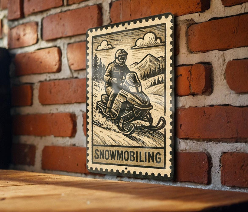 A metal sign featuring a snowmobile rider on a snowy mountain landscape, mounted on a brick wall.