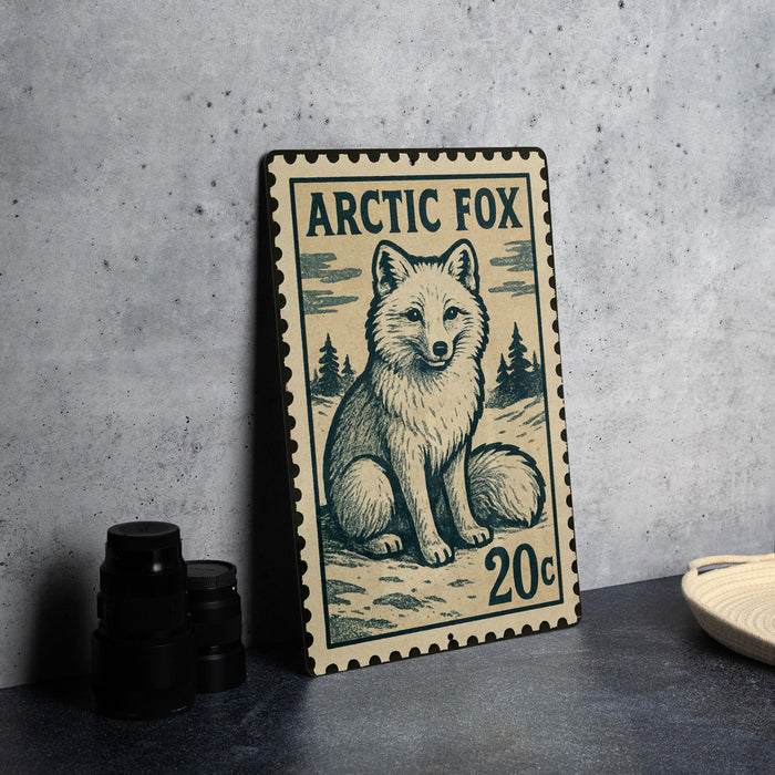 A metal stamp featuring an illustration of an Arctic fox, with the text "ARCTIC FOX" and "20c" printed on it.