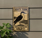 a sign with a bird illustration, mounted on a wall next to a plant.