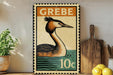 A vintage postage stamp featuring a bird, likely a crane, is displayed on a shelf next to a wooden cutting board and some lemons.
