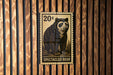A 20-cent stamp featuring a spectacled bear on a wooden background.