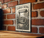 A metal sign with a garden swing illustration is mounted on a brick wall.