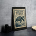 A framed image of a turtle on a black background, with a postage stamp-like design.