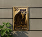 a large, detailed stamp-like sign depicting a spectacled bear, mounted on a wall.