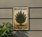 A metal sign with a rosemary bush illustration is mounted on a wall, with a plant to the left of the sign.