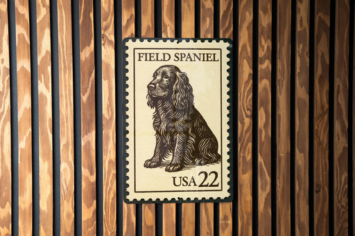 A Field Spaniel postage stamp from the United States, with the number 22 printed on it, is displayed on a wooden surface.