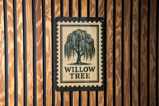 a sign with the text "WILLOW TREES" and a tree illustration, mounted on a wooden wall.