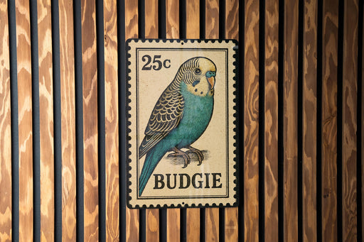 A 25c postage stamp featuring a budgie bird is displayed on a wooden wall.