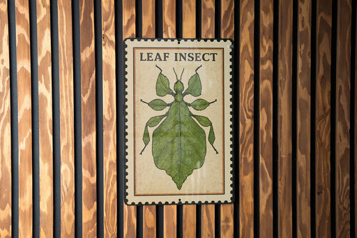 A metal sign with a leaf insect illustration is mounted on a wooden wall.