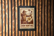 A wooden wall with a black rectangular sign featuring a man holding a bow and arrow, with the text "BOW HUNTING" below the illustration.