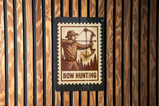 A wooden wall with a black rectangular sign featuring a man holding a bow and arrow, with the text "BOW HUNTING" below the illustration.