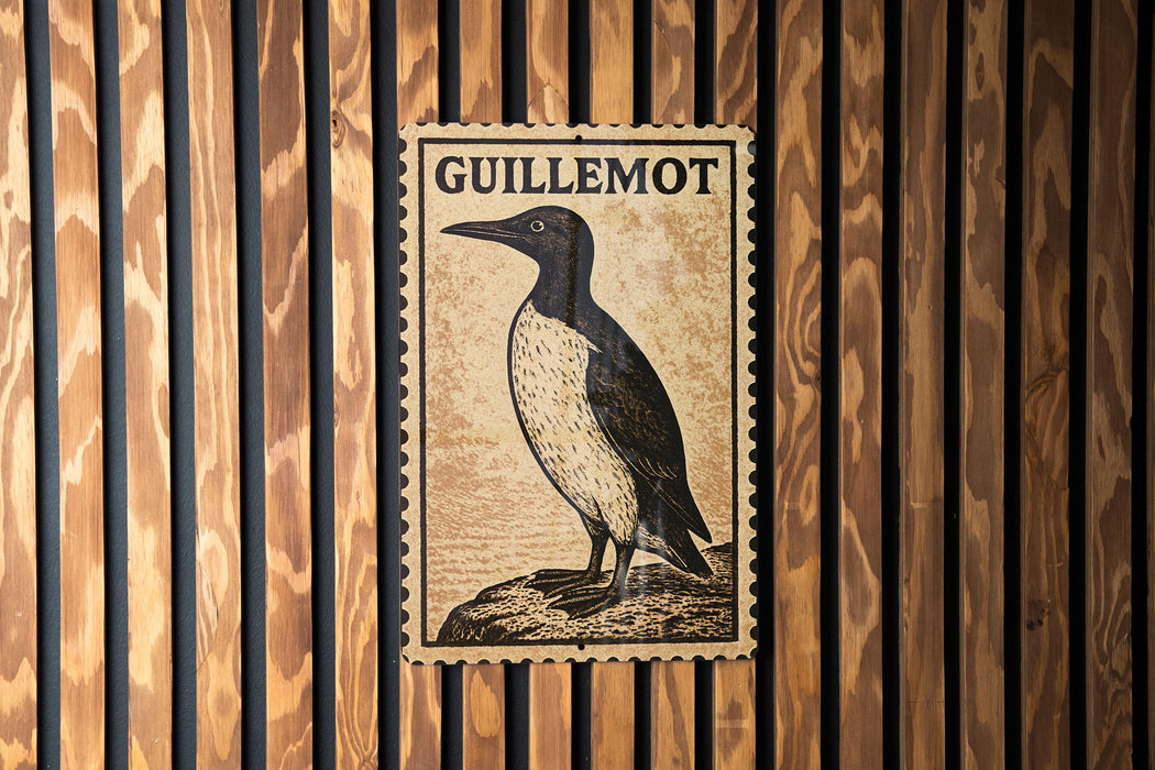 a postage stamp with a bird illustration, mounted on a wooden wall.