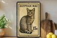 a framed illustration of an Egyptian Mau cat, which is a type of cat with distinctive spotted fur. The cat is sitting on a wooden surface, and there are some potted plants and kitchen utensils visible in the background.