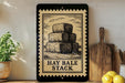 a framed illustration of hay bales stacked on top of each other, with the text "HAY BALE STACK" below the image.