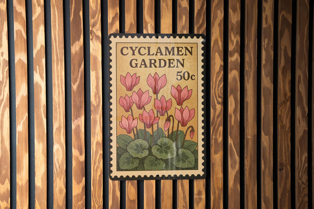 A vintage-style postage stamp featuring pink flowers and green leaves, mounted on a wooden wall.