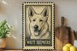 A framed illustration of a white shepherd dog is displayed on a shelf, accompanied by a wooden cutting board, a potted plant, and some lemons.