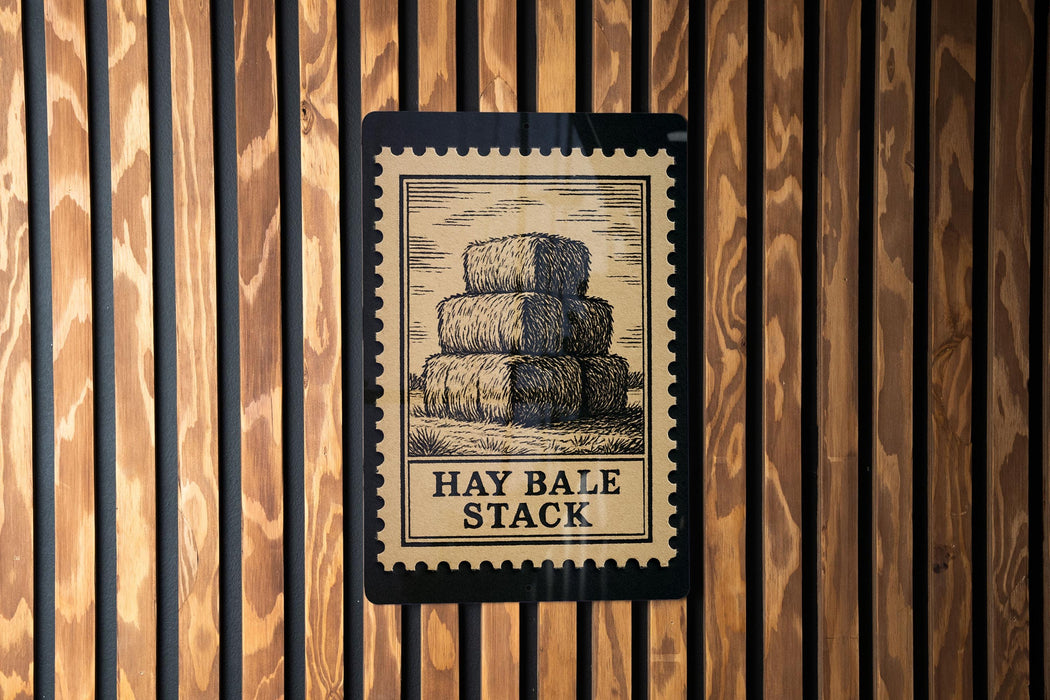 A sign with the text "HAY BALE STACK" is displayed on a wooden wall.