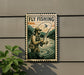 A vintage-style metal sign with a painting of a man fishing, mounted on a wall next to a plant.