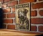 A vintage-style postage stamp featuring a dog's portrait is displayed on a brick wall.