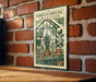 A vintage-style metal stamp with a green and white design depicting a greenhouse filled with various potted plants, mounted on a brick wall.