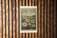 a sign with a floral design, hanging on a wooden wall.