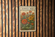 A vintage-style stamp or postcard with a floral illustration, hanging on a wooden wall.