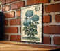 A vintage-style stamp depicting a blue hydrangea flower is mounted on a brick wall.