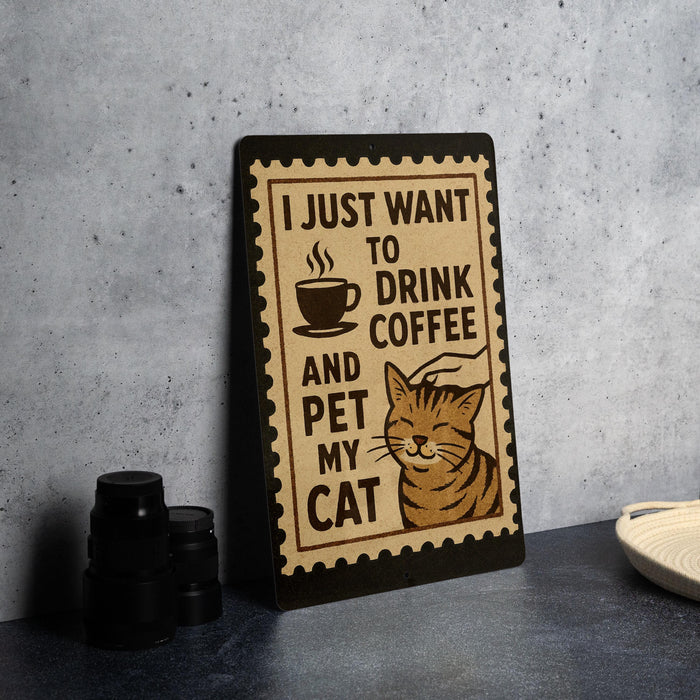 A sign with the text "I JUST WANT TO DRINK COFFEE AND PET MY CAT" is displayed on a table, accompanied by a cat illustration.