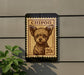 A small, square-shaped sign with a dog illustration and the text "CHIPOO" printed on it, mounted on a wall.