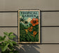 A tropical garden sign with palm trees and flowers is displayed on a wall, accompanied by a potted plant.