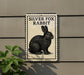 a sign with a black and white illustration of a rabbit, mounted on a wall.