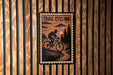 A sign with the text "TRAIL CYCLING" and an illustration of a person riding a bicycle on a trail.