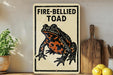 a sign with a picture of a fire-bellied toad, placed on a wooden surface next to a wooden cutting board and some lemons.
